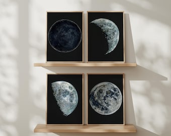 May include: Set of 4 framed prints featuring detailed watercolor depictions of the moon in various phases against a black background. The prints are displayed on wooden shelves. The text "SET OF 4 PRINTS" is at the top.