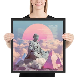 May include: A framed square wall art print featuring a grey stone Buddha statue sitting in a meditative pose amidst fluffy clouds and pink pyramids. A large pink sun sits in the background with digital glitch text and a grid pattern at the bottom.