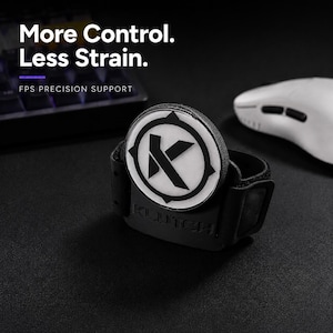 May include: A black wrist support device featuring a circular white emblem with a black letter K logo. The device is embossed with the word KLUTCH. Text in the image reads: More Control. Less Strain. FPS PRECISION SUPPORT.