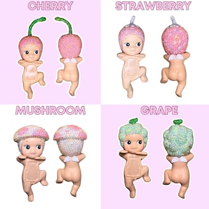 K&ouml;nnte beinhalten: Vier kleine Figuren in Babyform, jede mit einem Kopf zum Thema Obst oder Gem&uuml;se. Die Figuren sind mit "CHERRY", "STRAWBERRY", "MUSHROOM" und "GRAPE" beschriftet. Der Hintergrund ist hellrosa.