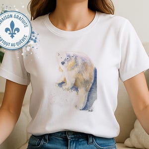 May include: White t-shirt with a watercolour illustration of a polar bear. The bear is shown in white, beige, and blue hues. The shirt has a classic crew neck and short sleeves. The design is centered on the front of the shirt.