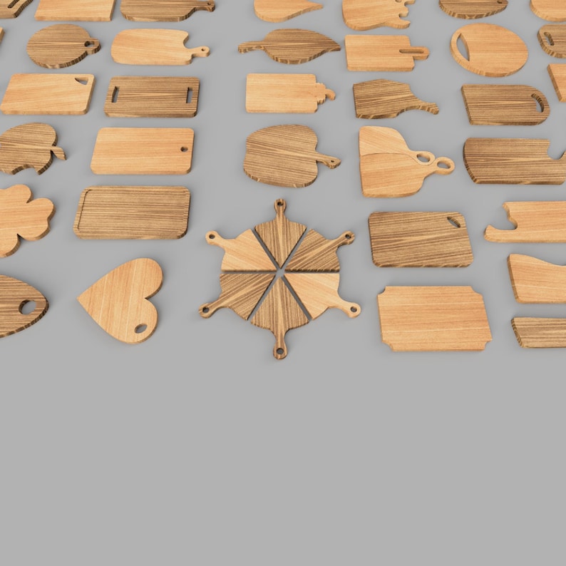 Op de afbeelding: Een verzameling verschillende houten snijplanken in verschillende vormen en maten, waaronder rechthoekige, ronde en hartvormige ontwerpen. De planken zijn gemaakt van lichtgekleurd hout en gerangschikt op een grijze ondergrond.