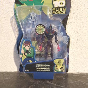 May include: A Ben 10 Alien Force action figure set in a clear plastic package. The package features a cartoon image of a boy and the text "Cromoraggio" and "Chromastone". The main figure is a dark purple alien with red accents.