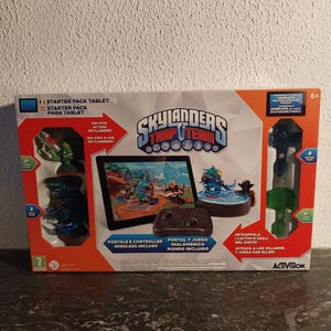 May include: A Skylanders Trap Team Starter Pack for tablet, including a tablet, wireless controller, and game portal. The box shows game characters and the game's logo. Includes a 6+ age rating and the Activision logo.