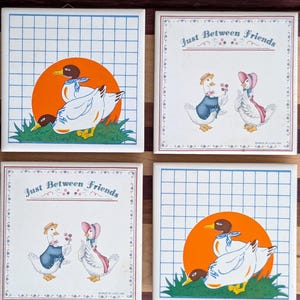 May include: Four square ceramic tiles with duck illustrations. Two tiles feature ducks in front of an orange sun, with a blue grid background. The other two tiles have ducks with the text "Just Between Friends".