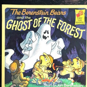 May include: A children's book cover featuring the title "The Berenstain Bears and the Ghost of the Forest." The illustration shows cartoon bears around a campfire with a ghost in the background. The book is labeled "First Time Readers."