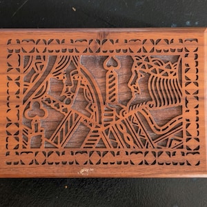 May include: A rectangular wooden box with a carved design featuring the King and Queen of Hearts playing card figures. The box is made of a dark brown wood with a decorative border.
