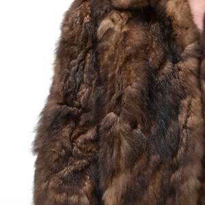 May include: A brown fur coat with a collar. The fur is soft and fluffy.