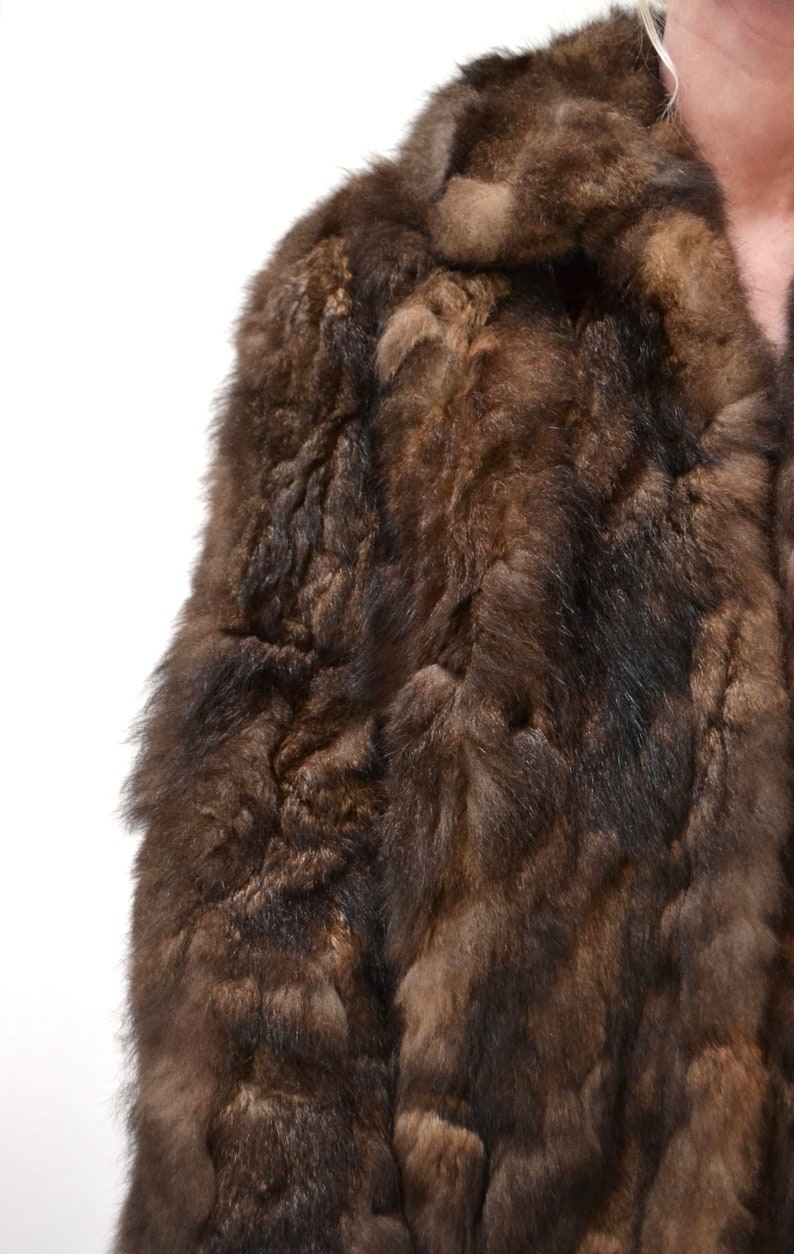 May include: A brown fur coat with a collar. The fur is soft and fluffy.