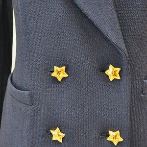 May include: A navy blue blazer with four gold star-shaped buttons.