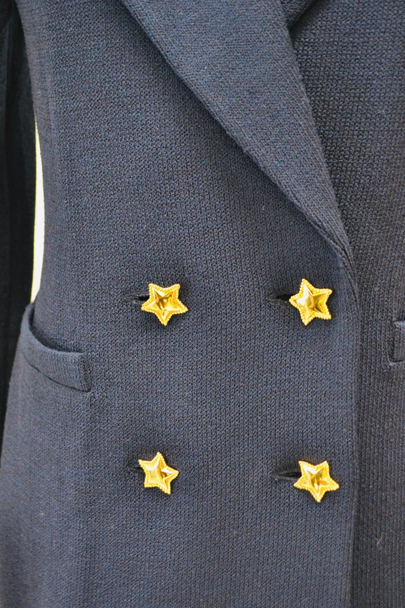 May include: A navy blue blazer with four gold star-shaped buttons.