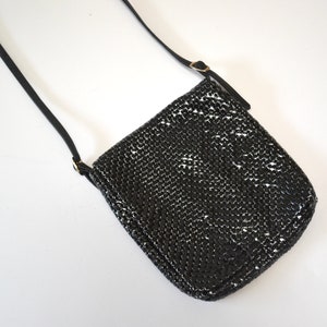 May include: A black chainmail crossbody bag with a long adjustable strap.