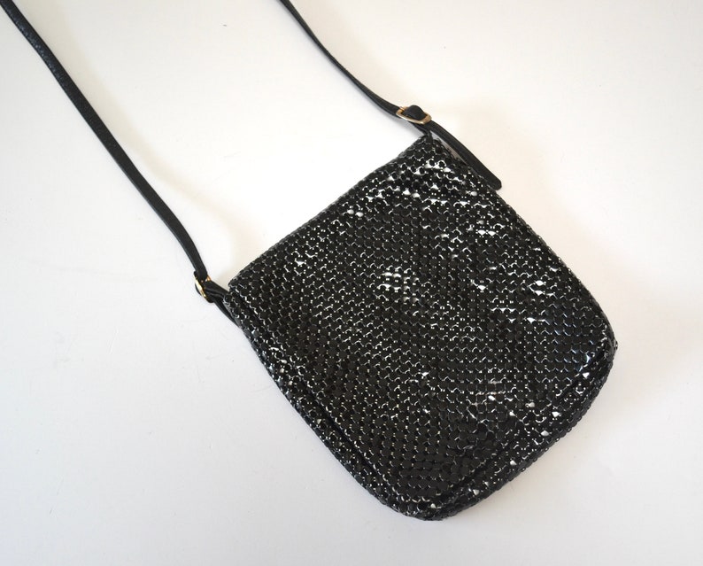 May include: A black chainmail crossbody bag with a long adjustable strap.