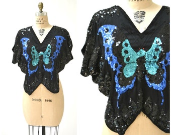 Camisa vintage con lentejuelas y mariposas, talla mediana, en negro y azul con mariposas. Camisa vintage con lentejuelas metálicas, estilo bohemio para festivales.