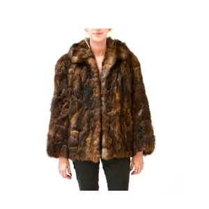 May include: A brown fur jacket with a collar and long sleeves.