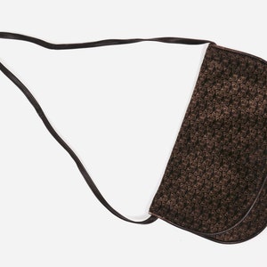 May include: A brown leather shoulder bag with a black and brown patterned design. The bag has a long strap and a flap closure.