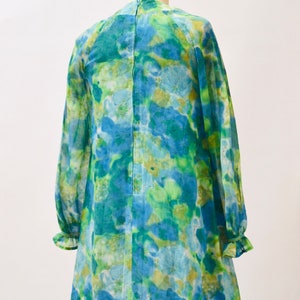 May include: A blue and green floral print mini dress with long sleeves and a ruffled hem.