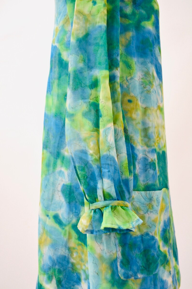 May include: A blue and green floral print dress with a ruffled sleeve detail.