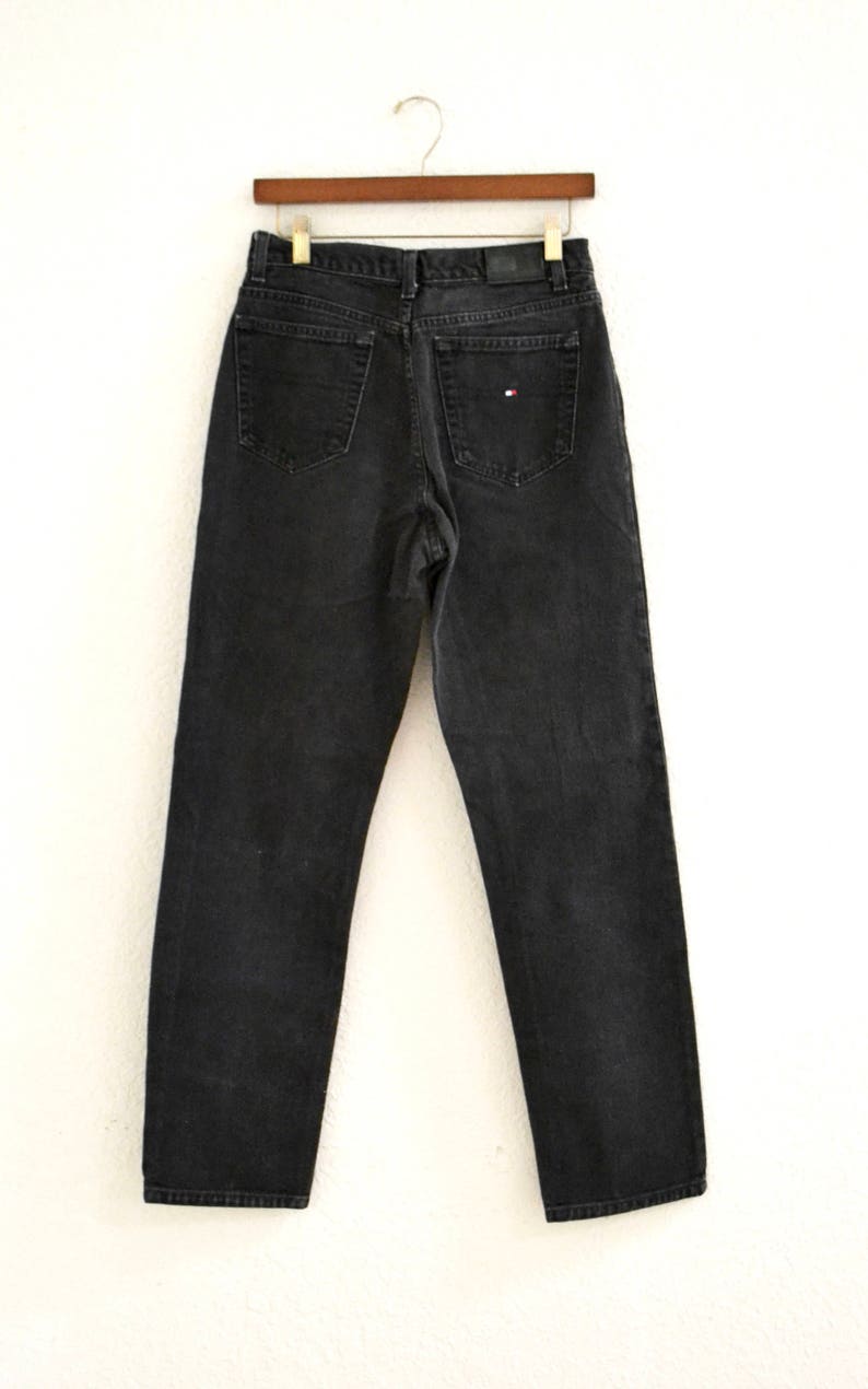 May include: Black denim jeans with a small red, white, and blue logo on the back pocket.