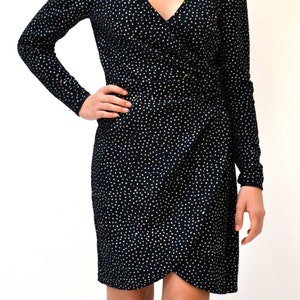 May include: A black wrap dress with a sparkly, dotted pattern. The dress has long sleeves and a V-neckline.
