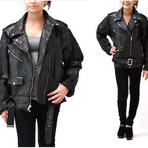 May include: Black leather motorcycle jacket with a zipper closure, two front pockets, and a belt at the waist.