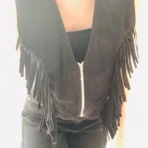 May include: A black suede vest with fringe detailing and a zipper closure.