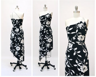 Puede incluir: Un vestido de estampado floral negro y blanco con una tira de un solo hombro y un dobladillo alto-bajo.