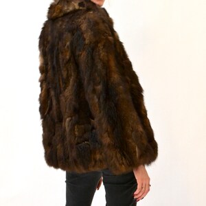 May include: A brown fur jacket with a collar. The jacket is made of a soft, luxurious fur.