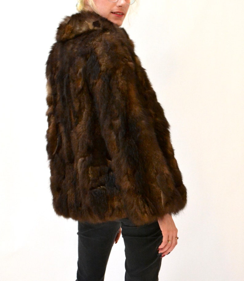May include: A brown fur jacket with a collar. The jacket is made of a soft, luxurious fur.