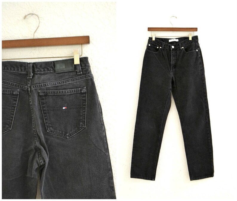 May include: A pair of black denim jeans with a small red, white, and blue logo on the back pocket.
