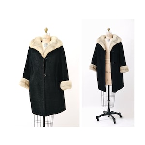 May include: A black coat with a white fur collar and cuffs. The coat is on a white background.