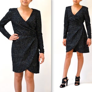 May include: A black wrap dress with a white polka dot pattern and long sleeves.