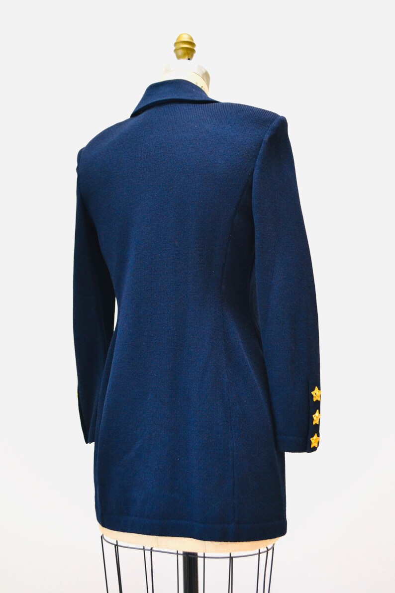 May include: A navy blue blazer with gold star buttons on the sleeves.