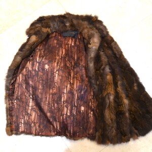 May include: A brown fur vest with a brown and white patterned lining. The vest is made of real fur and has a classic style.