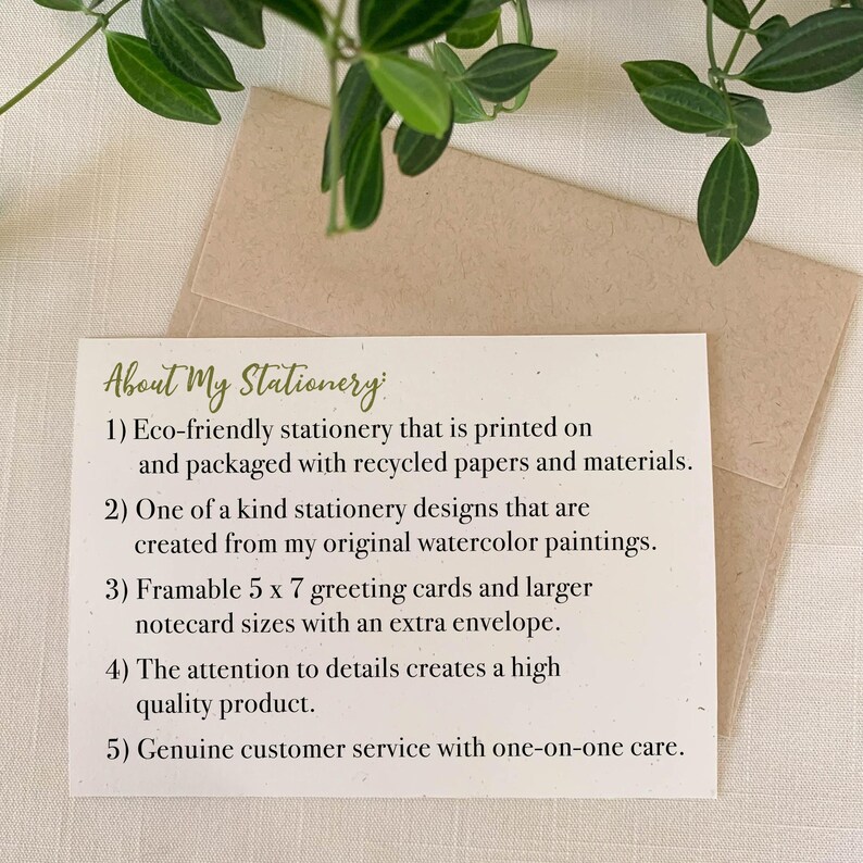 K&ouml;nnte beinhalten: Eine rechteckige wei&szlig;e Karte mit der &Uuml;berschrift About My Stationery und f&uuml;nf nummerierten Punkten zu umweltfreundlichen Praktiken, originalen Aquarell-Designs, 12,7 x 17,8 cm Gru&szlig;karten, Qualit&auml;t und Service, platziert auf einem beigen Umschlag.