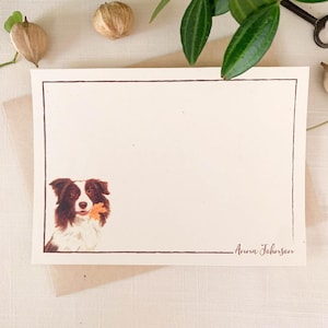May include: Cream-colored stationery with a brown border and a watercolor illustration of a brown and white dog holding a leaf. The name "Anna Johnson" is written in a script font at the bottom right.