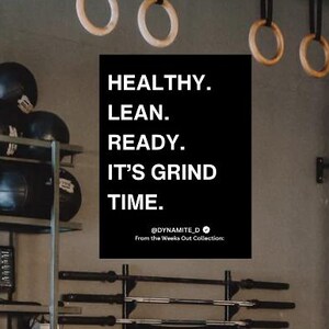 Può includere: Interno di una palestra con varie attrezzature per il fitness, tra cui palle mediche, kettlebell e bilancieri. Un cartello sulla parete recita "HEALTHY. LEAN. READY. IT'S GRIND TIME."