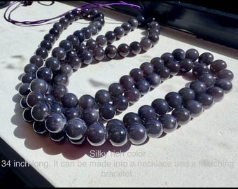 May include: A long strand of dark, smooth, spherical beads with a silky rich color. The strand is 34 inches long and is arranged in a looped formation. The text on the image reads: Silky rich color. 34 inch long. It can be made into a necklace and a matching bracelet.