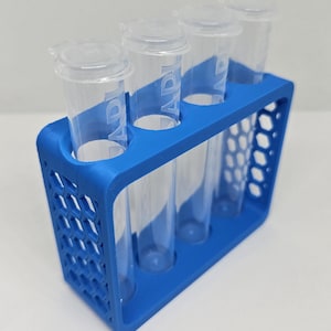 May include: A blue 3D-printed test tube rack holding four clear plastic test tubes with white lids. The rack has a honeycomb design on the side and a rectangular shape. The test tubes have the word "API" printed on them.