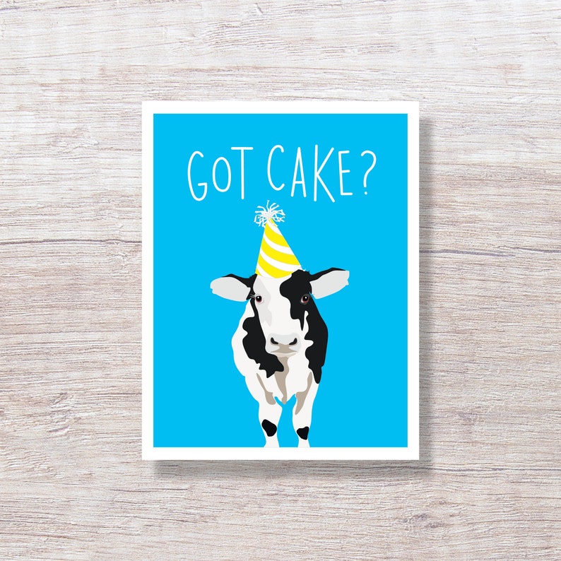May include: A blue card with the text "GOT CAKE?" in white. A black and white cow with a yellow party hat is in the center of the card.
