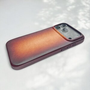 Close-up of the rich, textured brown patina leather surface of the iPhone case, highlighting craftsmanship and quality.