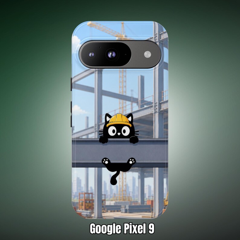 Op de afbeelding: Een Google Pixel 9 telefoonhoesje met een cartoon zwarte kat die een gele veiligheidshelm draagt en aan een stalen balk hangt op een bouwplaats met een kraan op de achtergrond. De tekst Google Pixel 9 staat onderaan de afbeelding.