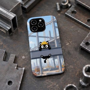 Op de afbeelding: Een smartphonehoesje met een cartoon zwarte kat die een gele veiligheidshelm draagt en aan een stalen balk op een bouwplaats hangt. De achtergrond toont een blauwe lucht en een stadsskyline met kranen en stalen constructies in de verte.