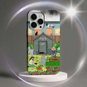 May include: A phone case featuring a garden scene with a shed, vegetables, and people gardening. The case has a light gray top and a white base. The shed has a welcome sign and a Union Jack flag. The words "NO BALL GAMES" are visible.