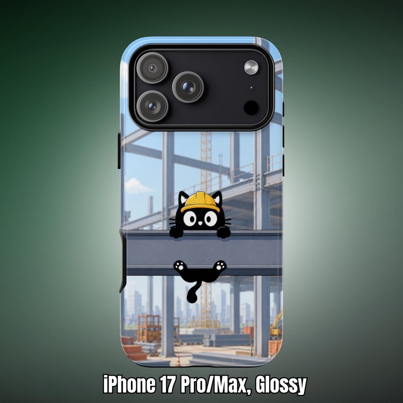 Op de afbeelding: Een glanzend telefoonhoesje voor de iPhone 17 Pro Max met een cartoon zwarte kat met een gele veiligheidshelm, zittend op een stalen constructiebalk. De achtergrond toont een bouwplaats met stalen balken en een verre stadsskyline.