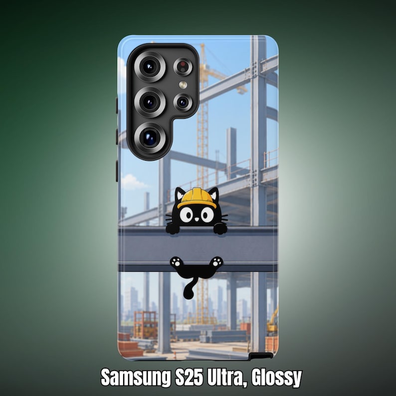 Op de afbeelding: Een glanzend Samsung S25 Ultra telefoonhoesje met een cartoon zwarte kat die een gele veiligheidshelm draagt, zittend op een stalen balk. De achtergrond toont een blauwe lucht, stalen balken en een gele kraan in de verte.