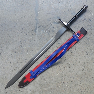 May include: A long, silver sword with a black handle and crossguard rests beside its sheath. The sheath is red with blue straps and a brown base. The sword's blade is approximately 36 inches long.