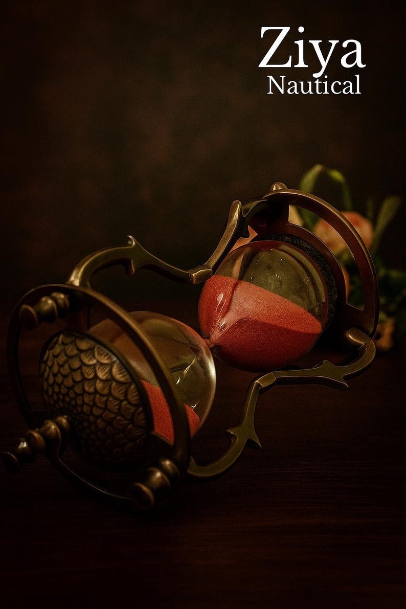 May include: An antique-style hourglass with a bronze-colored frame and red sand. The glass bulbs are connected by a decorative metal structure. The text "Ziya Nautical" is displayed at the top.