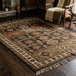 May include: A rectangular area rug featuring a dark brown, olive green, and burnt orange geometric pattern with repeating star and diamond motifs. The rug has a decorative border and short fringe along the edges, with the text RugHavenCraft visible.