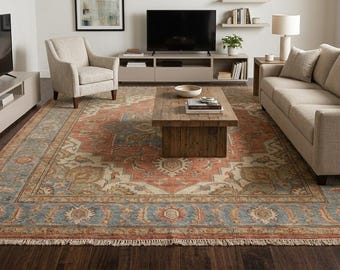 May include: A large rectangular area rug featuring a central medallion design in shades of terracotta, muted blue, and cream. The rug has a wide decorative border with floral motifs and short white fringe along the two shorter ends of the textile.